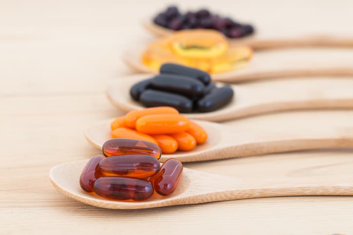 Healthy Vitamin supplement capsules in a spoons.